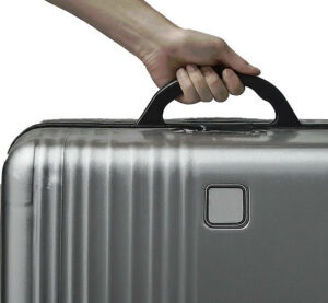 hand holding a silver suitcase by the handle