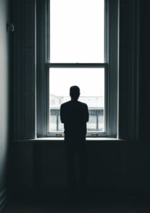silhouette of person standing in front of window at daytime