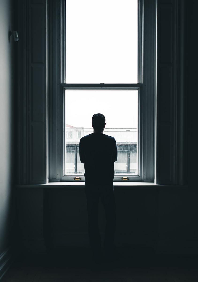 silhouette of person standing in front of window at daytime